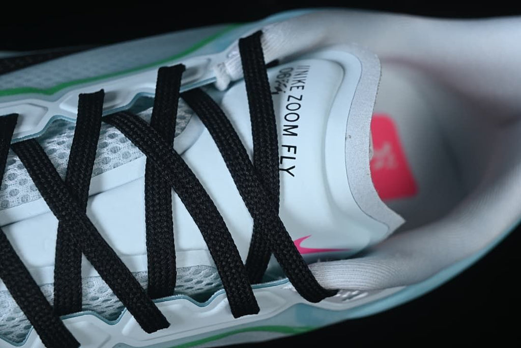 Top-down close-up of black laces and Nike Zoom Fly tongue branding.