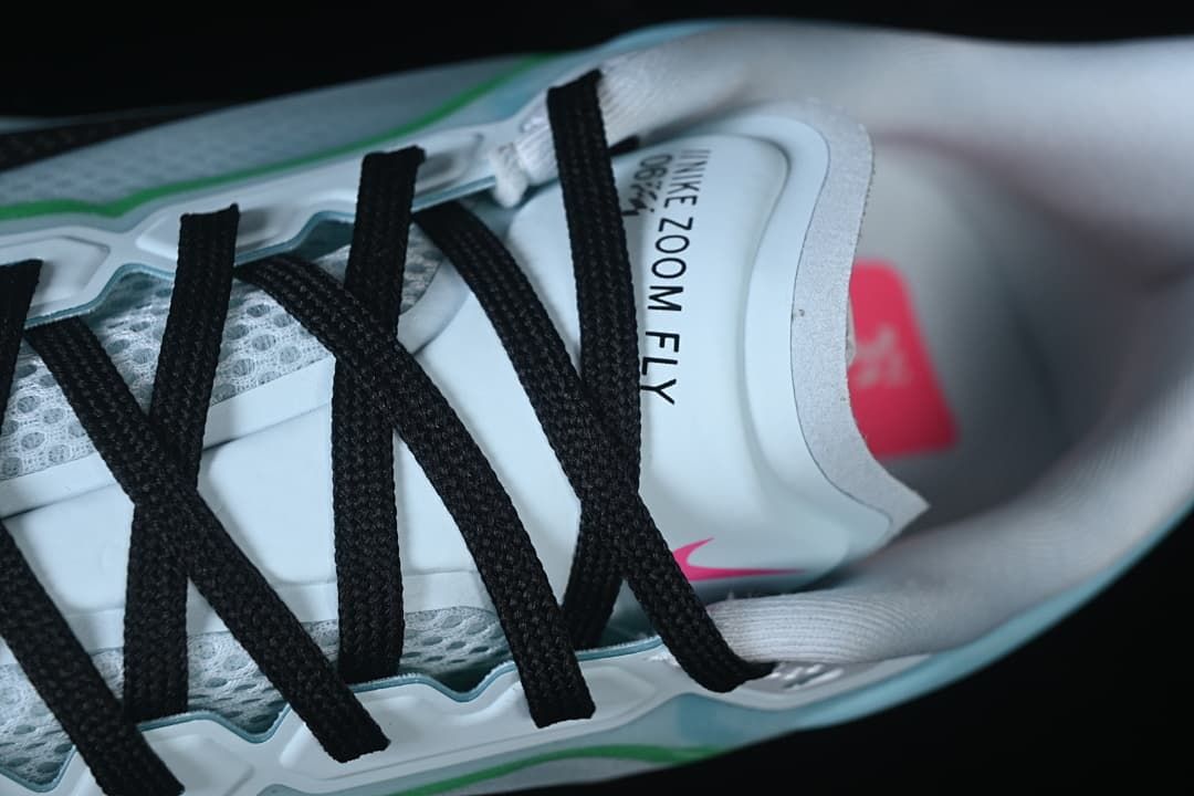Top-down close-up of black laces and Nike Zoom Fly tongue branding.