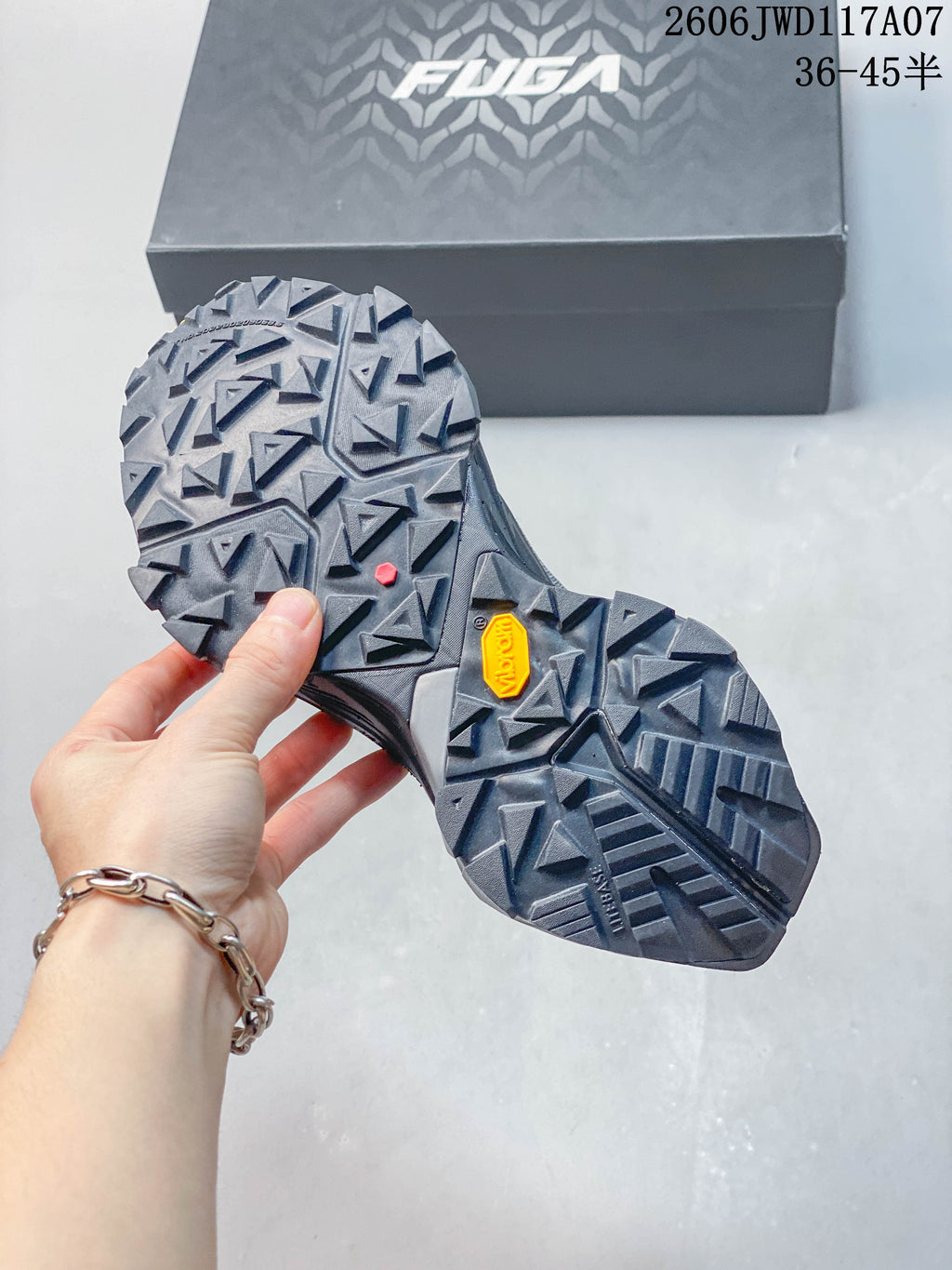 Close-up of the trail shoes’ lugged outsole and FUGA shoe box