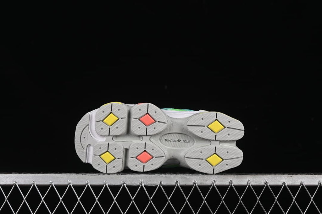 Underside view of the gray outsole with yellow and coral accents