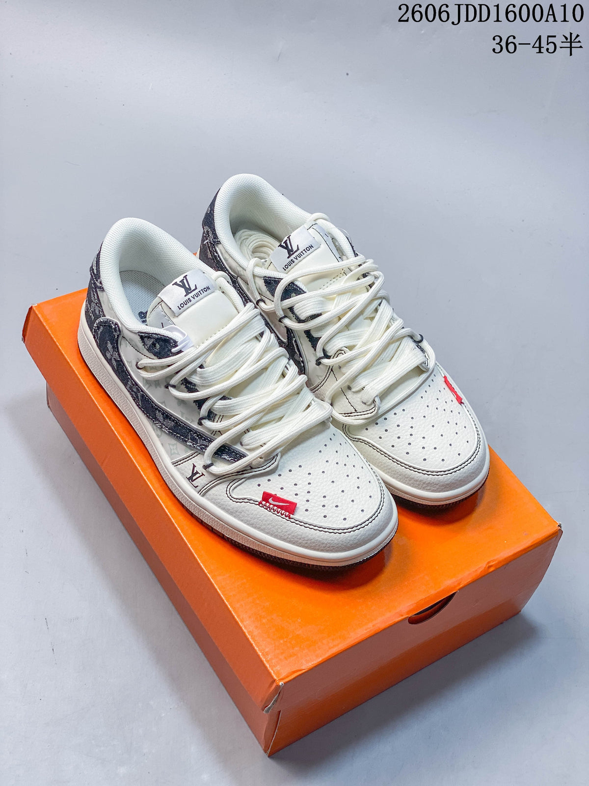 Pair of off-white and gray low-top sneakers with patterned overlays and cream laces on an orange box