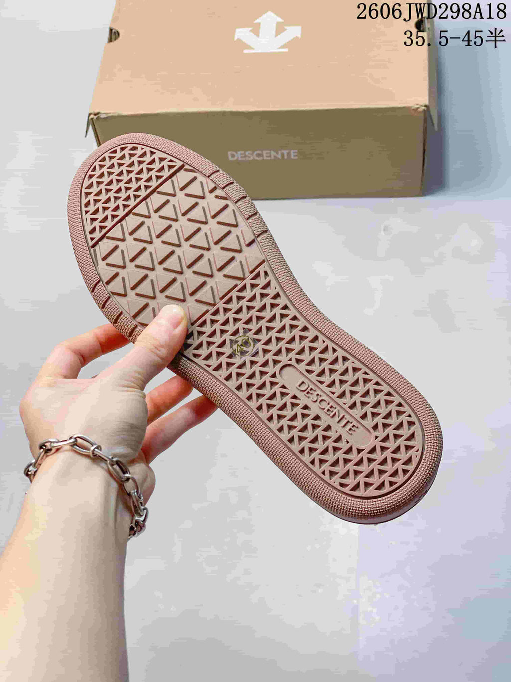 Close-up of the patterned brown-toned outsole of a Descente sneaker
