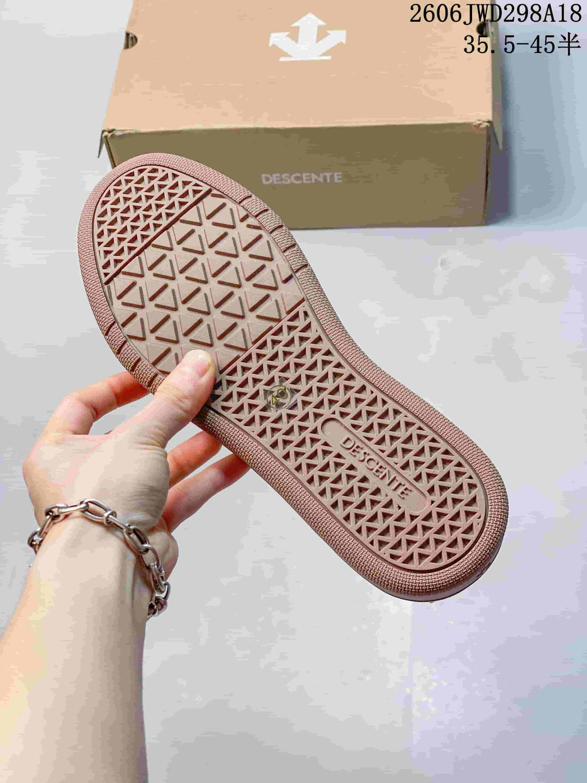 Close-up of the patterned brown-toned outsole of a Descente sneaker