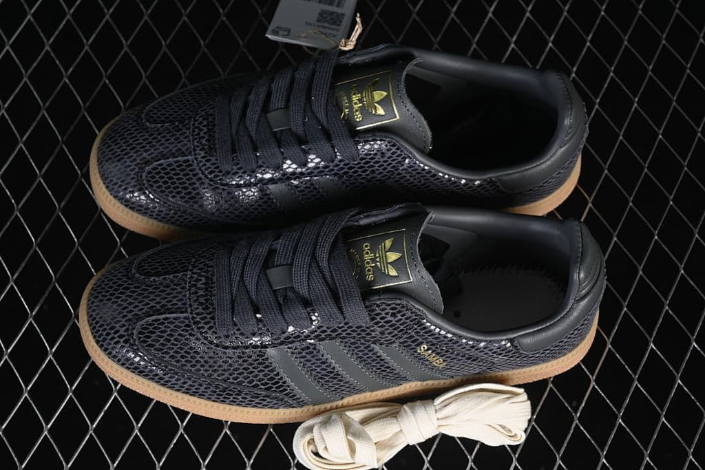 Pair of dark grey patterned Samba OG sneakers with an extra light-colored lace pair
