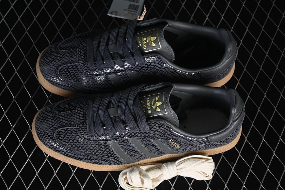 Pair of dark grey patterned Samba OG sneakers with an extra light-colored lace pair