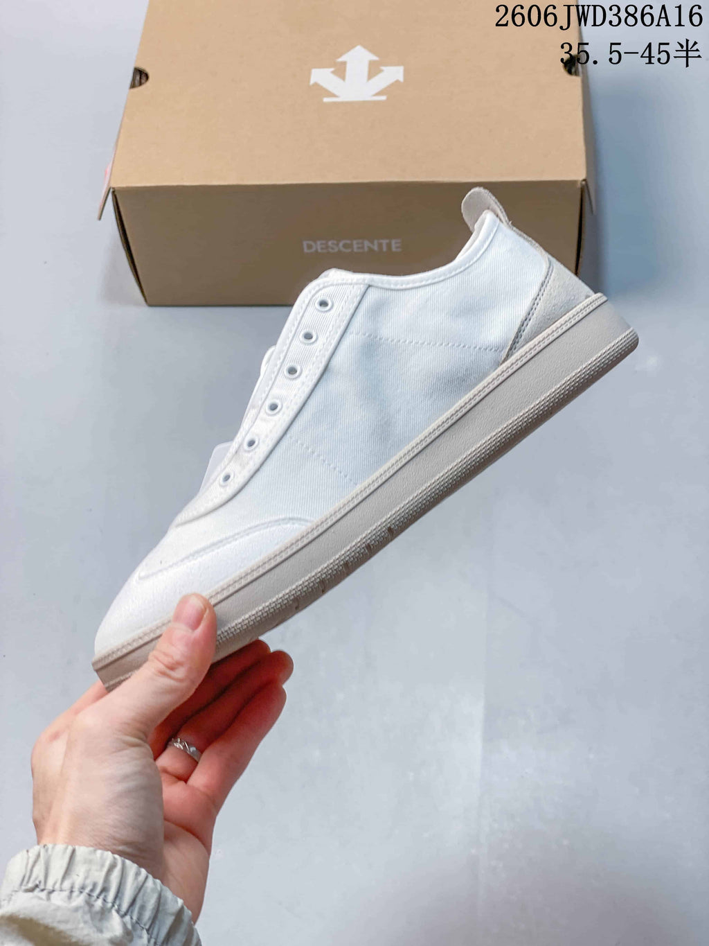 Side view of the white low-top sneaker with an eyelet panel and heel pull tab