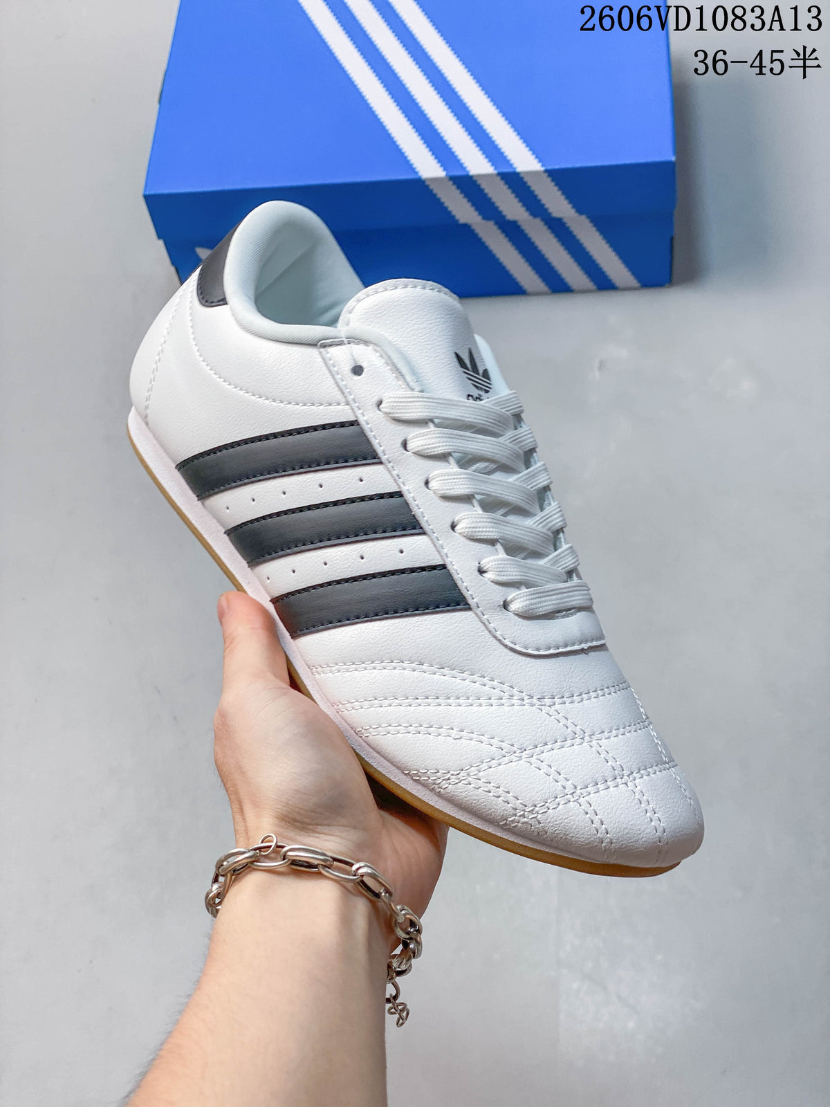 Angled side view of a white low-top sneaker with dark stripes and laces