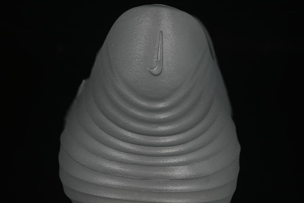 Rear view showing the heel and ridged sole of the grey clog