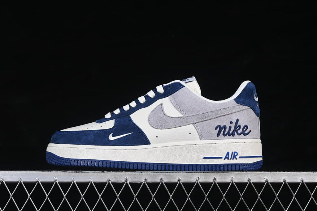 Side view of a low-cut white, gray, and navy Nike Air Force 1 '07 sneaker.