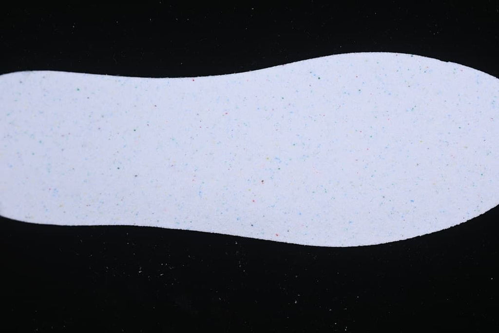 Plain light-colored shoe insole shown against a dark background