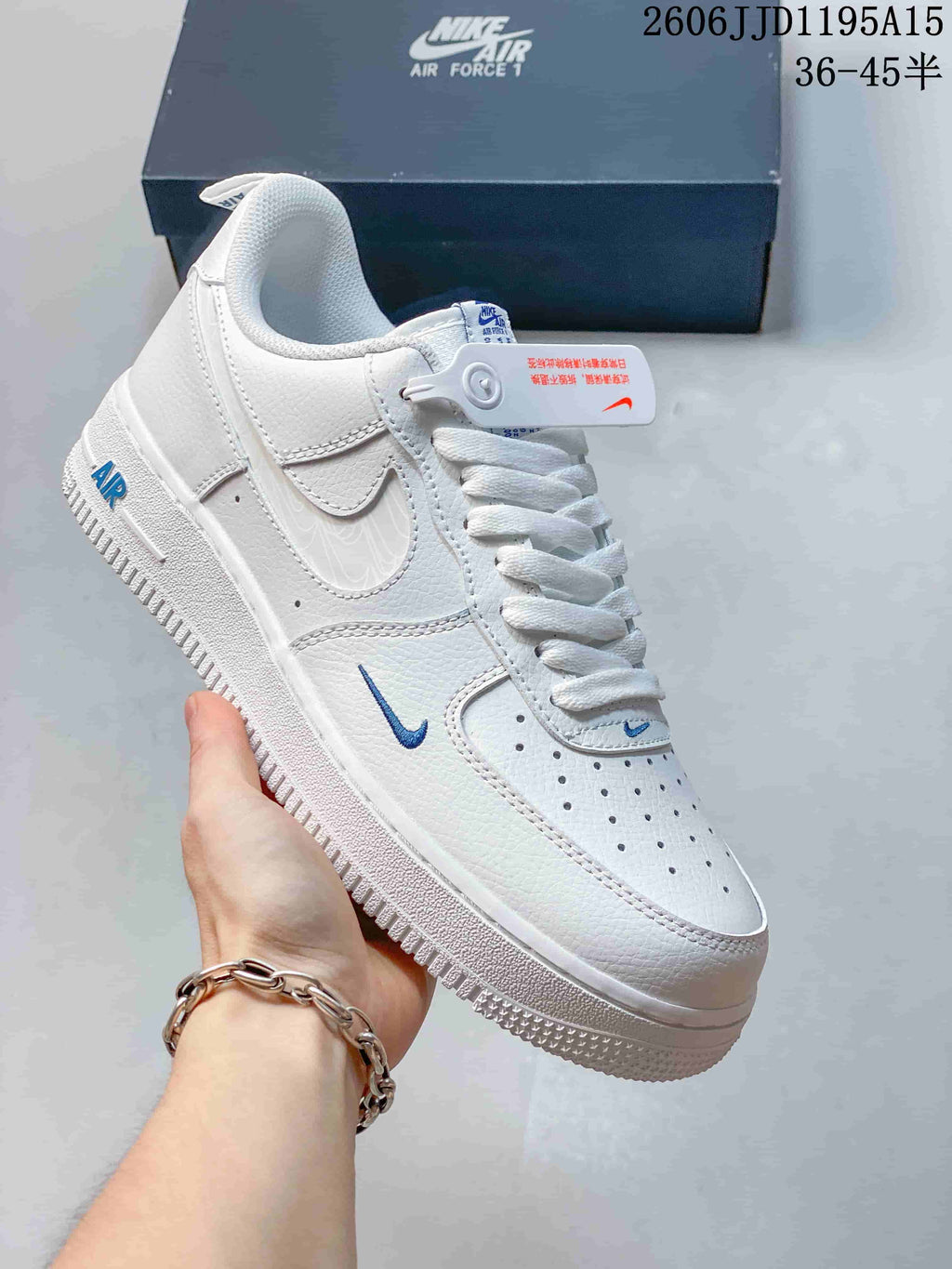 Side view of a white low-top sneaker with blue accent details and a perforated toe.