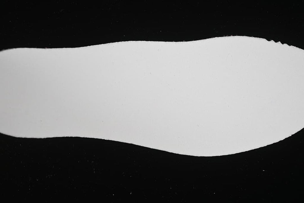 Plain white background surface photographed against black
