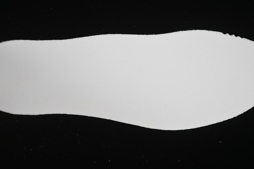 Plain white background surface photographed against black
