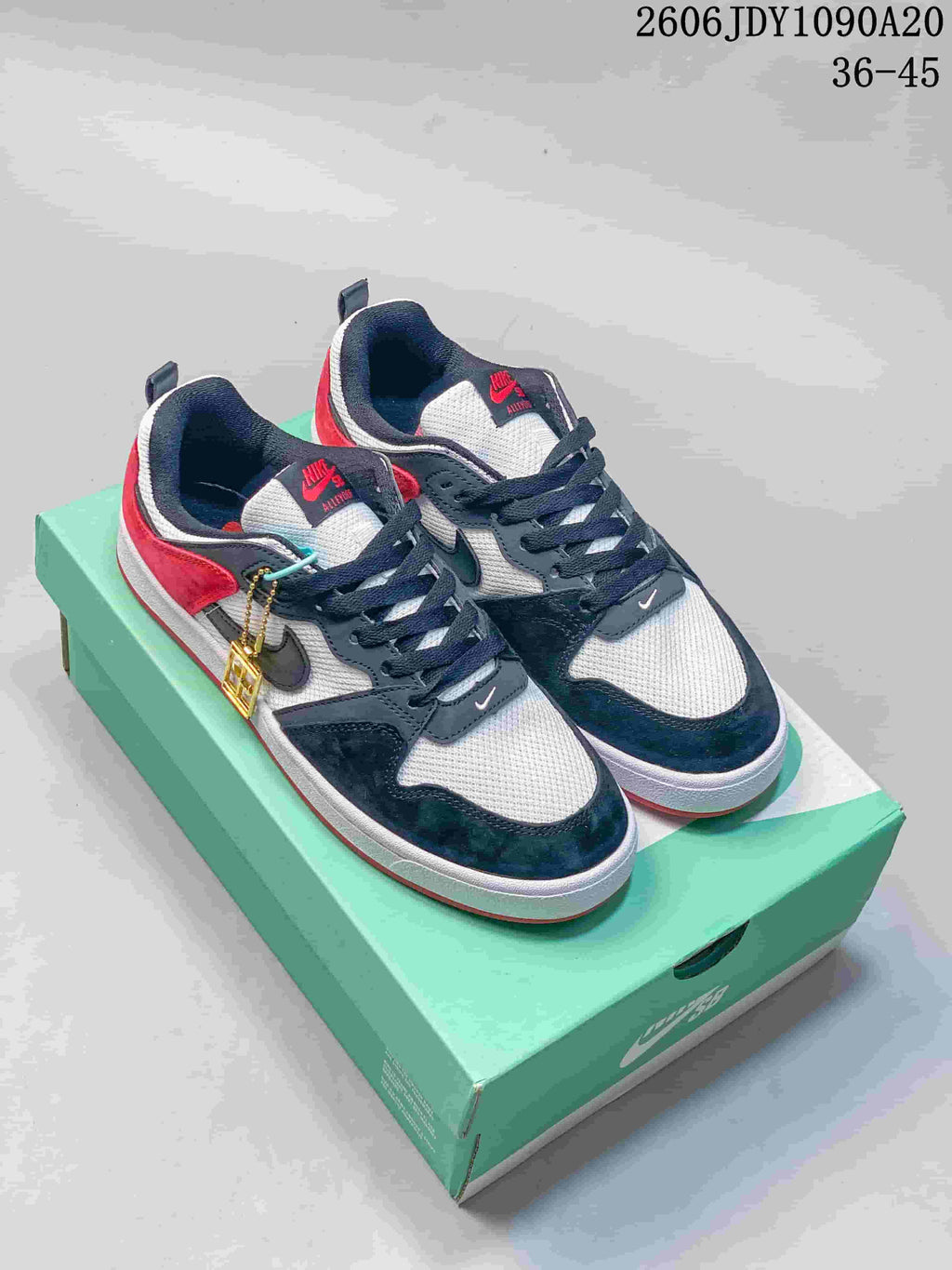 Pair of black, white, and red Nike SB Alleyoop low-top sneakers on a green shoebox