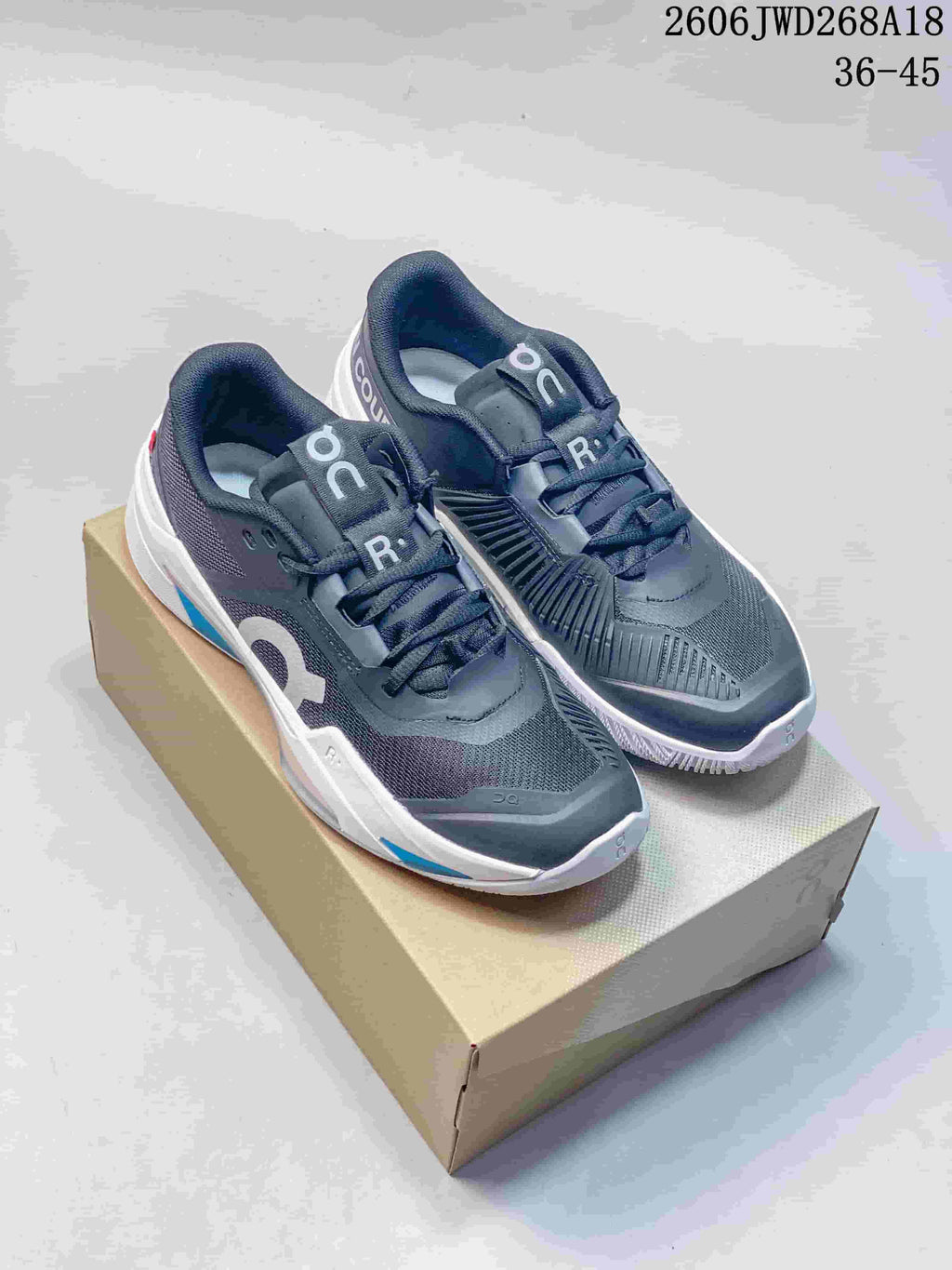 Pair of gray On The Roger Pro Fire tennis shoes with white and blue accents, shown from above and at an angle.