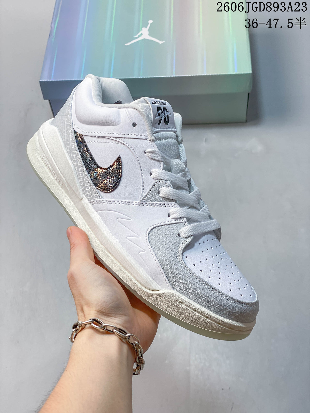 White and gray Jordan Stadium 90 sneaker with a metallic patterned side logo