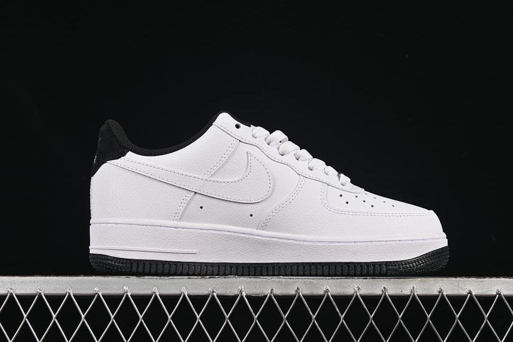 Side profile of the white low-top sneaker with a black outsole