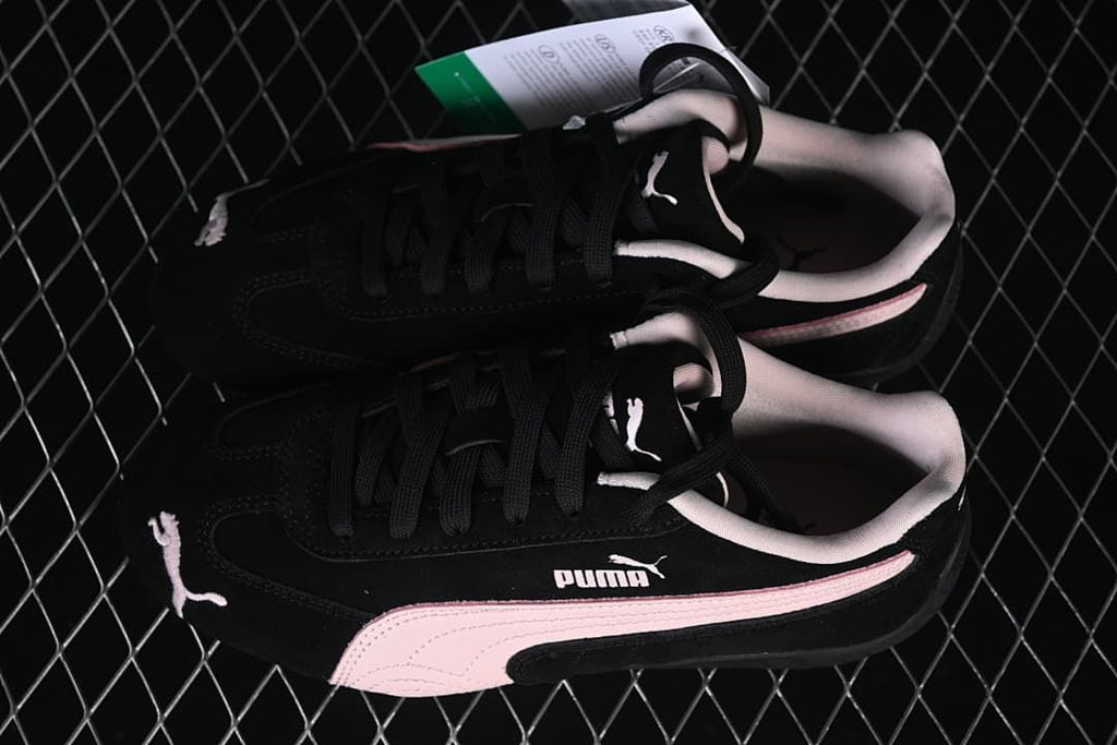 Overhead view of the pair of black and pale pink Puma sneakers.