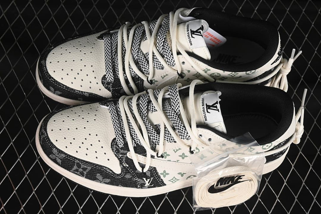 Overhead view of a pair of black and cream patterned low-top sneakers with green motifs and an extra set of laces.
