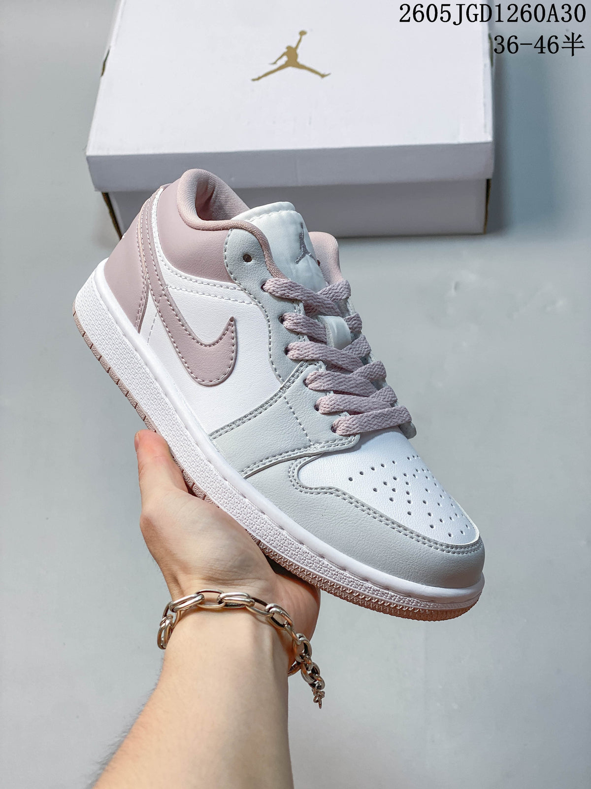 Angled side view of the white and blush-pink low-top sneaker