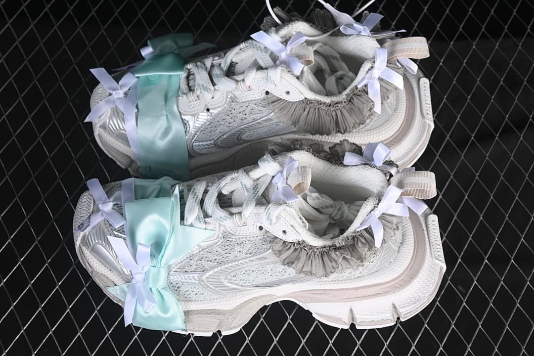 Pair of light silver sneakers with pale aqua bows and gray ruffle trim