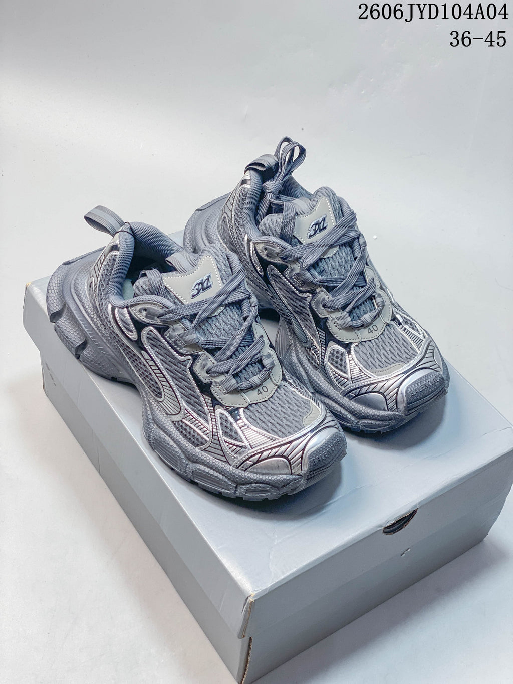 Pair of metallic gray Balenciaga 3XL sneakers shown on a box; image overlay states sizes 36–45.