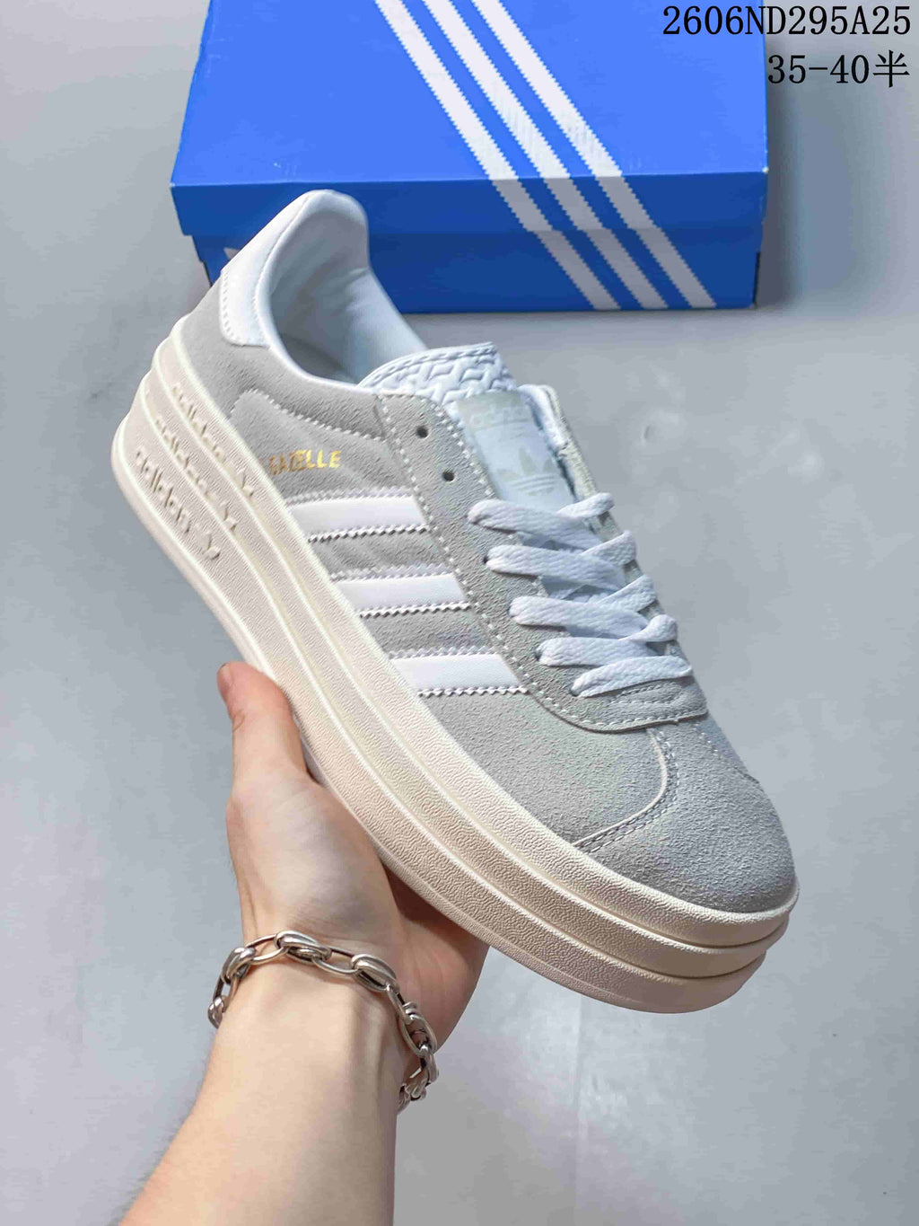 Gray and white low-top sneaker with white stripes and laces and a light-colored raised sole.