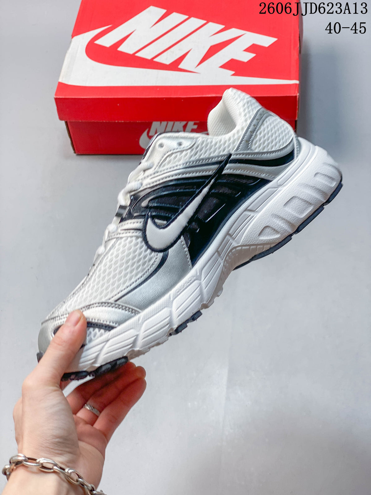 Side profile of the Nike Air Max Moto 2K sneaker showing layered panels and side Swoosh