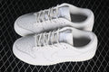 Pair of white Nike SB Dunk Low sneakers shown from above, with perforated toes and tonal side Swooshes.