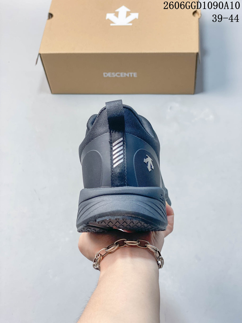 Rear view of a dark gray Descente sneaker with heel pull tab and logo; image text lists sizes 39–44.