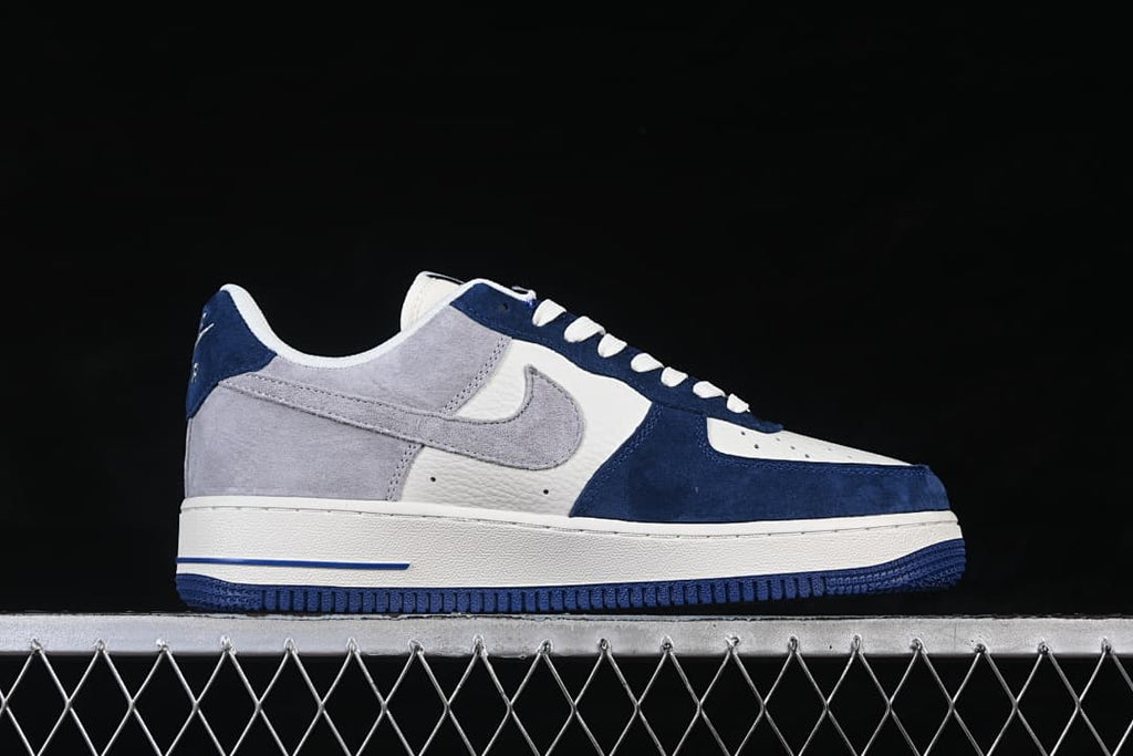 Side profile of the low-cut sneaker with gray Swoosh, navy overlays, and white midsole.