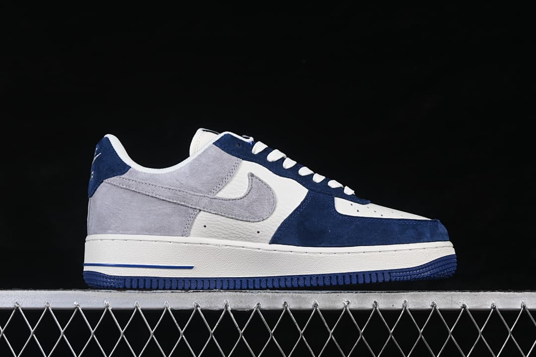 Side profile of the low-cut sneaker with gray Swoosh, navy overlays, and white midsole.