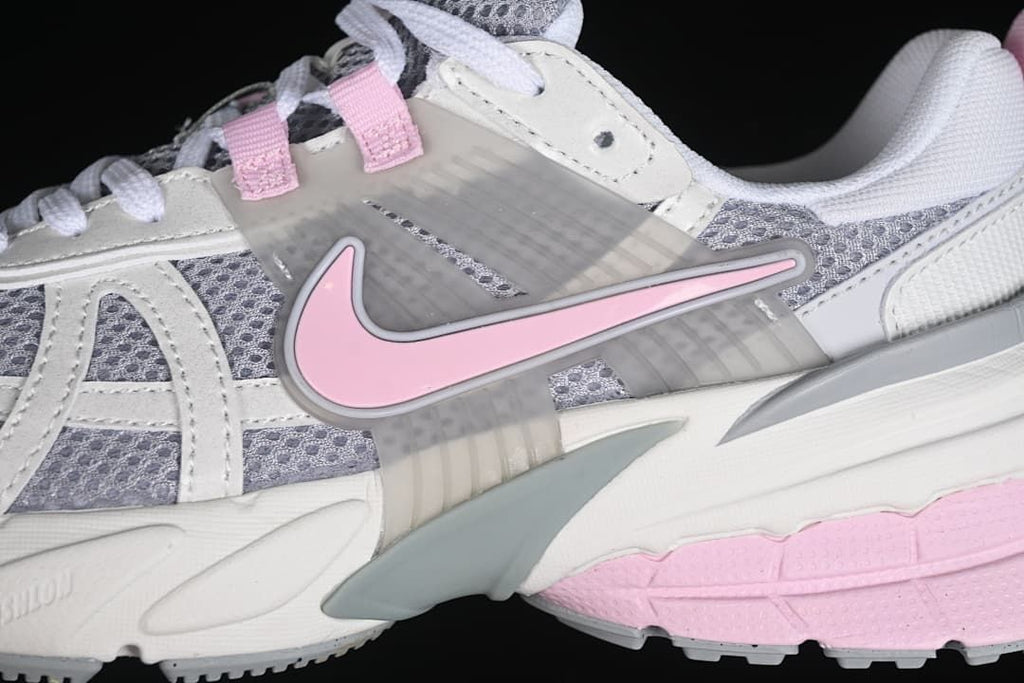 Close-up of the pink side Swoosh, grey mesh, and layered panels.