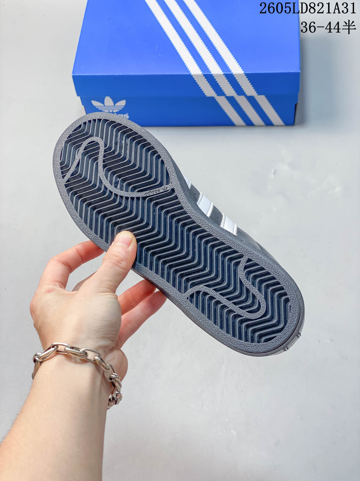 Close-up of the patterned dark outsole of an Adidas Superstar sneaker.