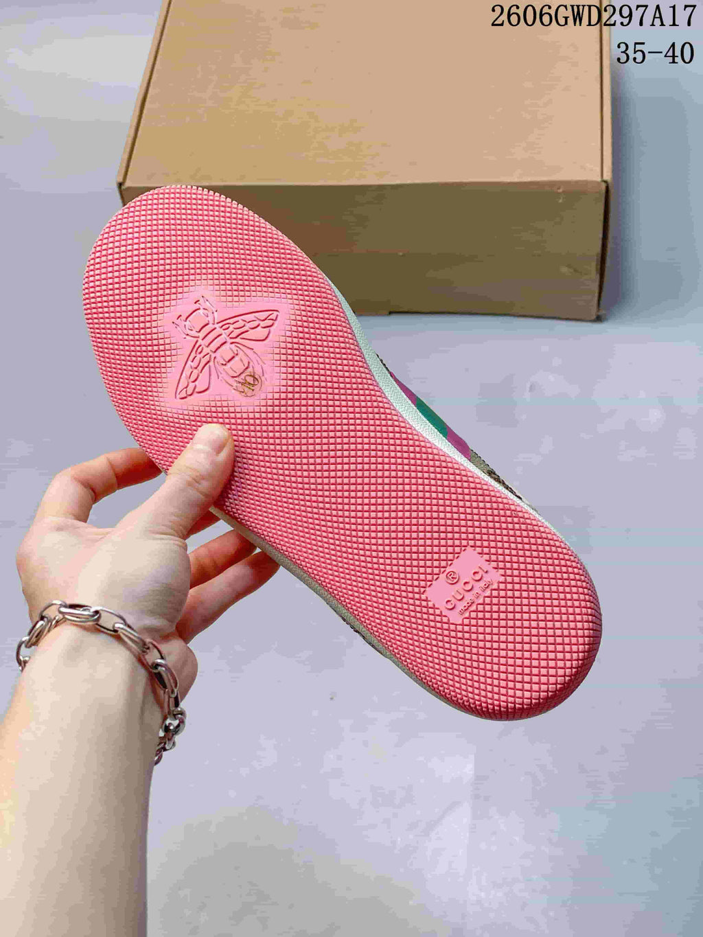 Pink textured outsole with an embossed bee motif and Gucci lettering.
