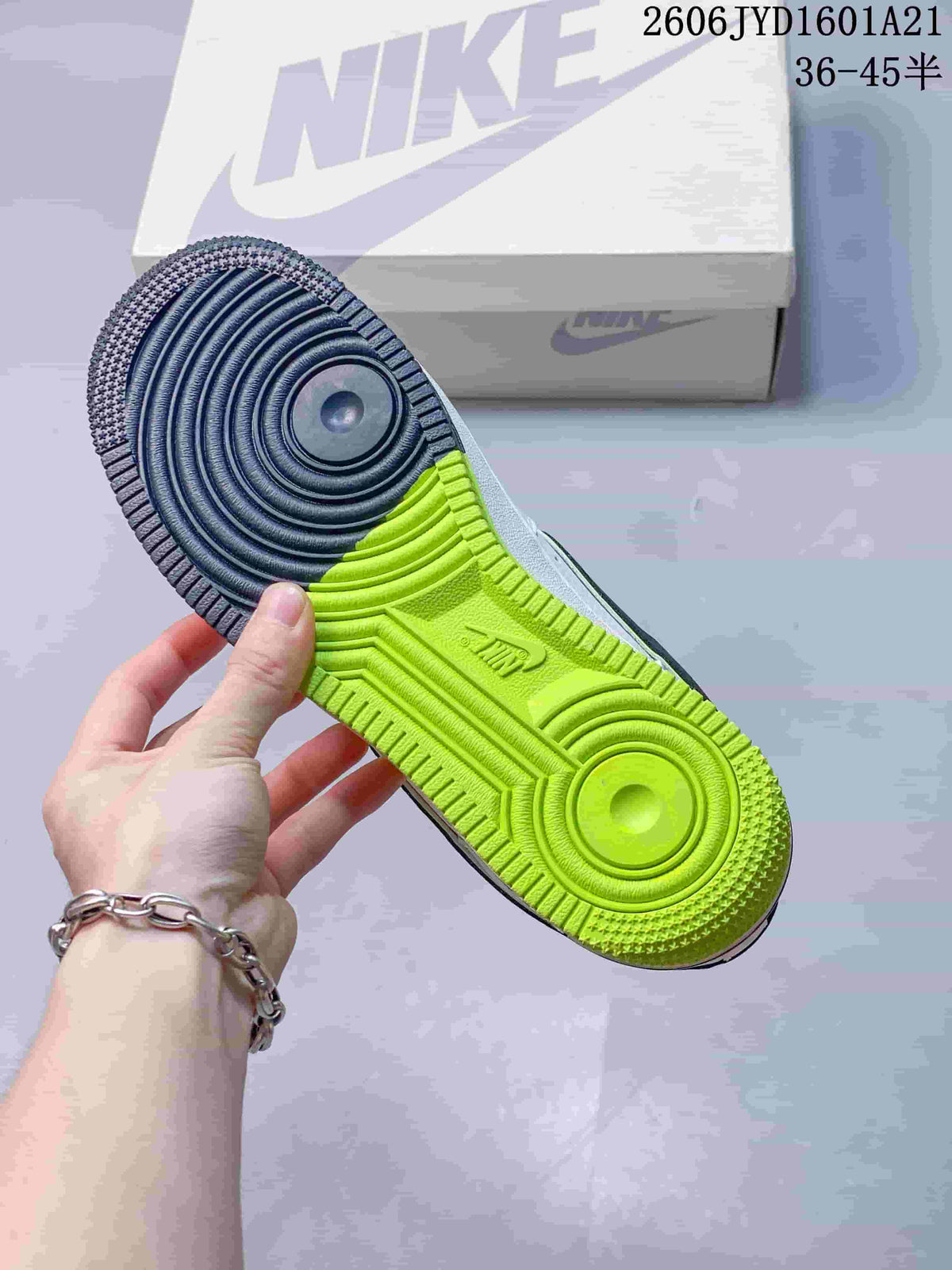 Underside of the sneaker showing a navy and bright lime outsole