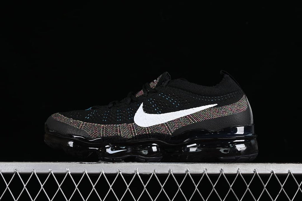 Black Nike Air VaporMax 2023 Flyknit sneaker with white Swoosh and multicolor knit accents, side view