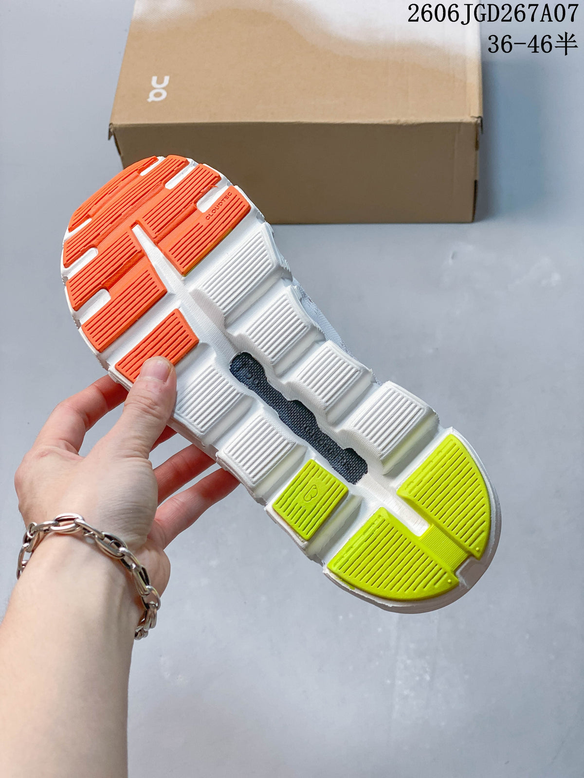 Underside of the sneaker showing an outsole with orange and yellow-green sections