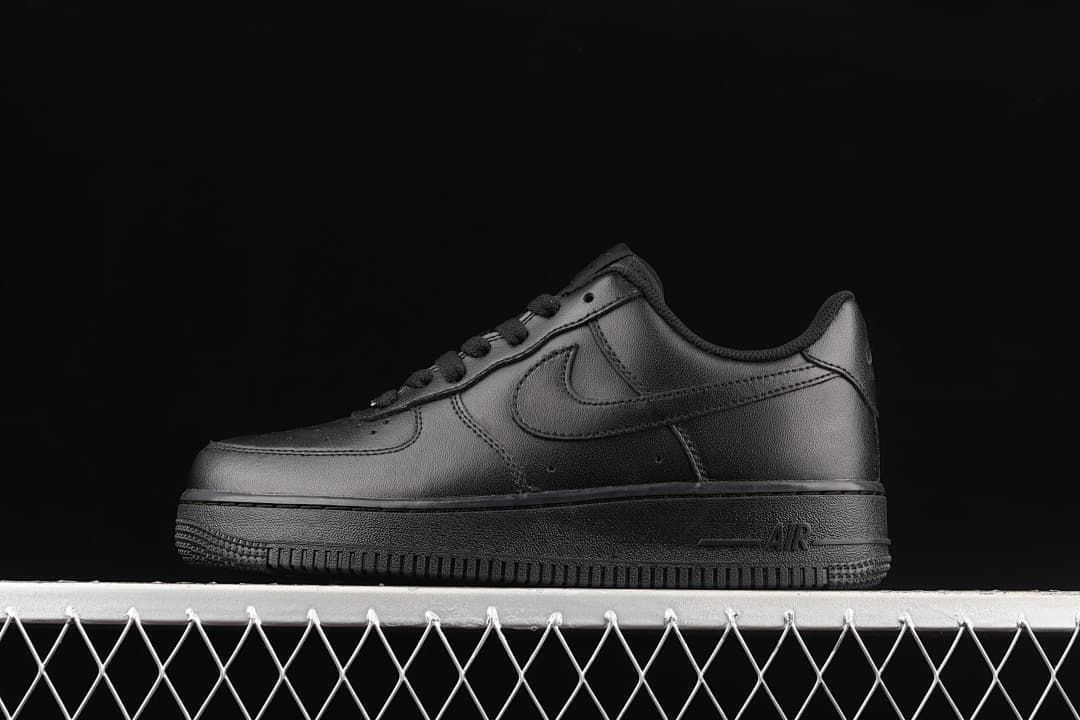 Side view of the all-black sneaker against a dark background.