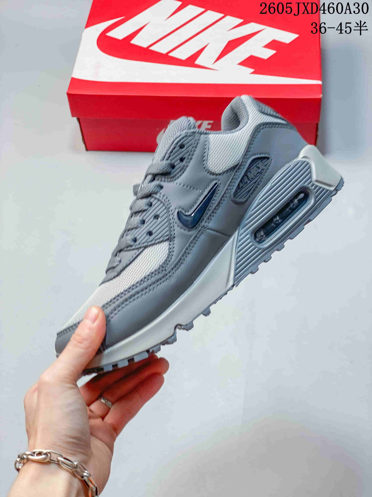 Side view of a grey Nike Air Max 90 sneaker showing the heel Air unit