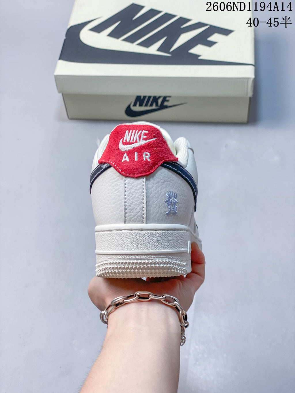 Rear view showing the red heel tab and navy trim on the white sneaker