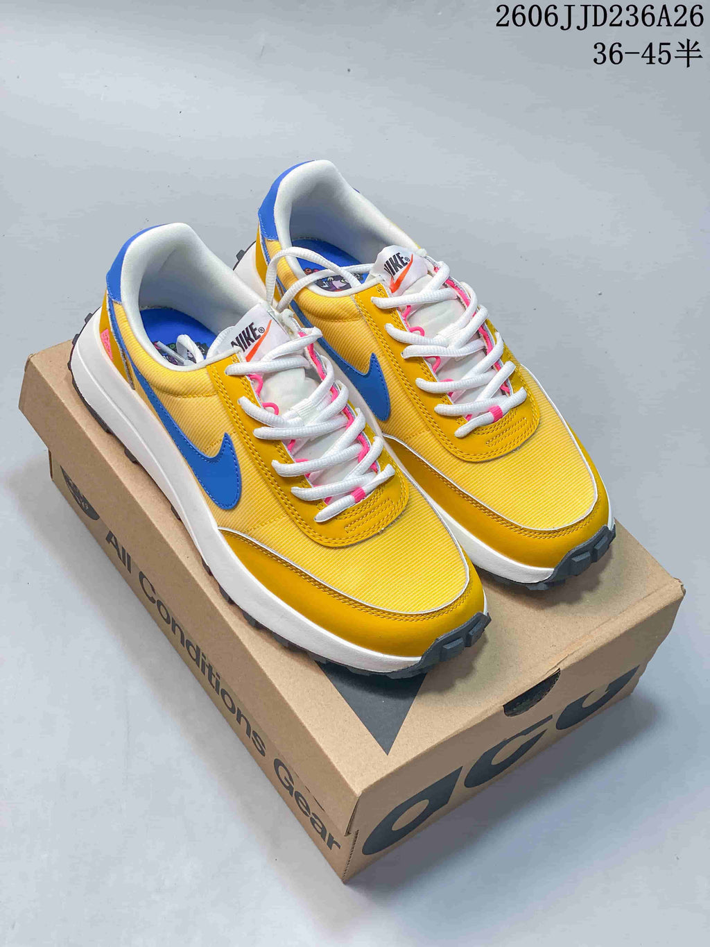 Pair of yellow Nike ACG LDV sneakers with blue Swoosh accents and white laces.
