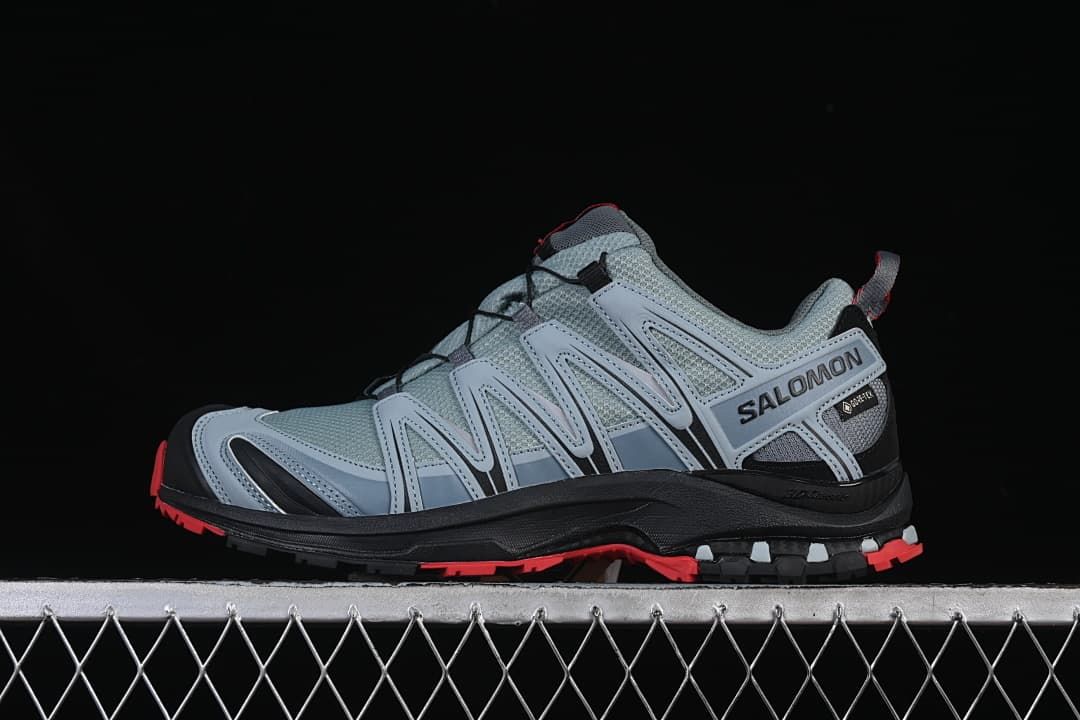 Side profile of gray Salomon trail shoes with black and red details