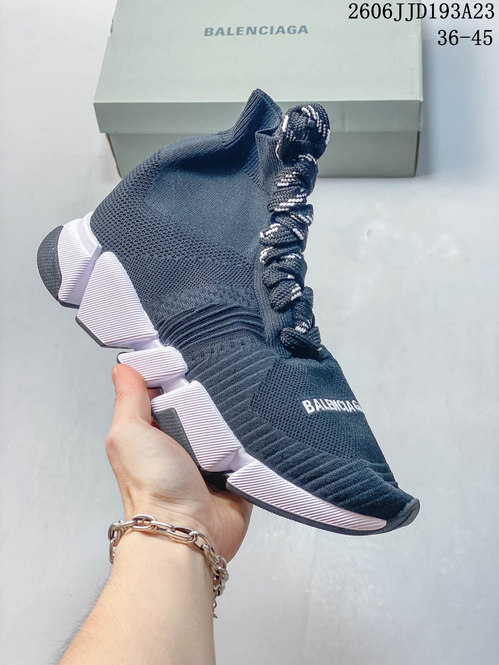 A navy high-top Balenciaga sneaker with patterned laces and pale segmented sole accents.