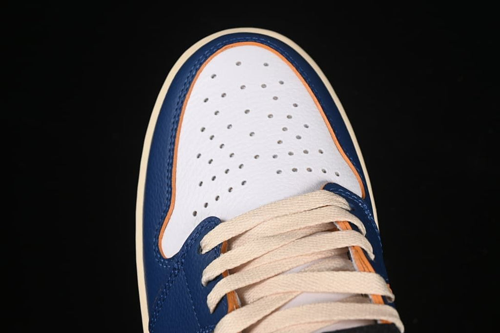 Top view of the perforated white toe and cream-colored laces