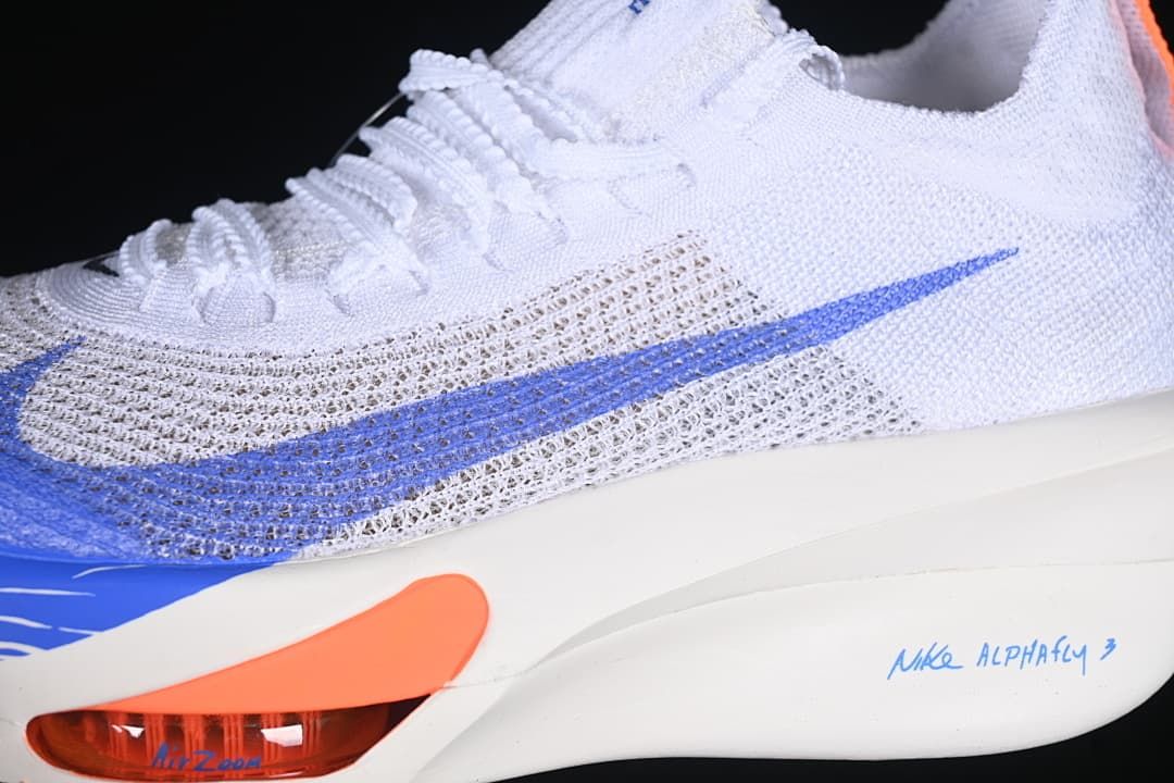 Close-up of the knit-style upper, blue Swoosh, and orange sole detail