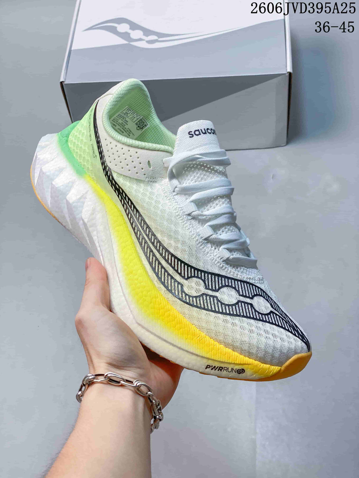 Close-up of a white Saucony Endorphin Speed 5 shoe with yellow and green accents.