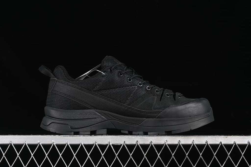 Side profile of the black sneaker with its reinforced toe and lugged sole