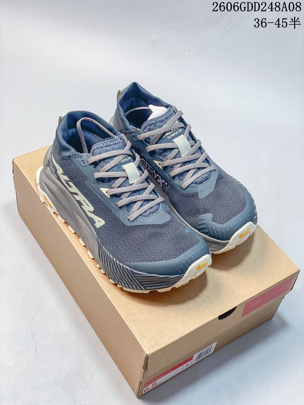 Pair of blue-gray Altra Olympus 275 running shoes displayed on a shoebox
