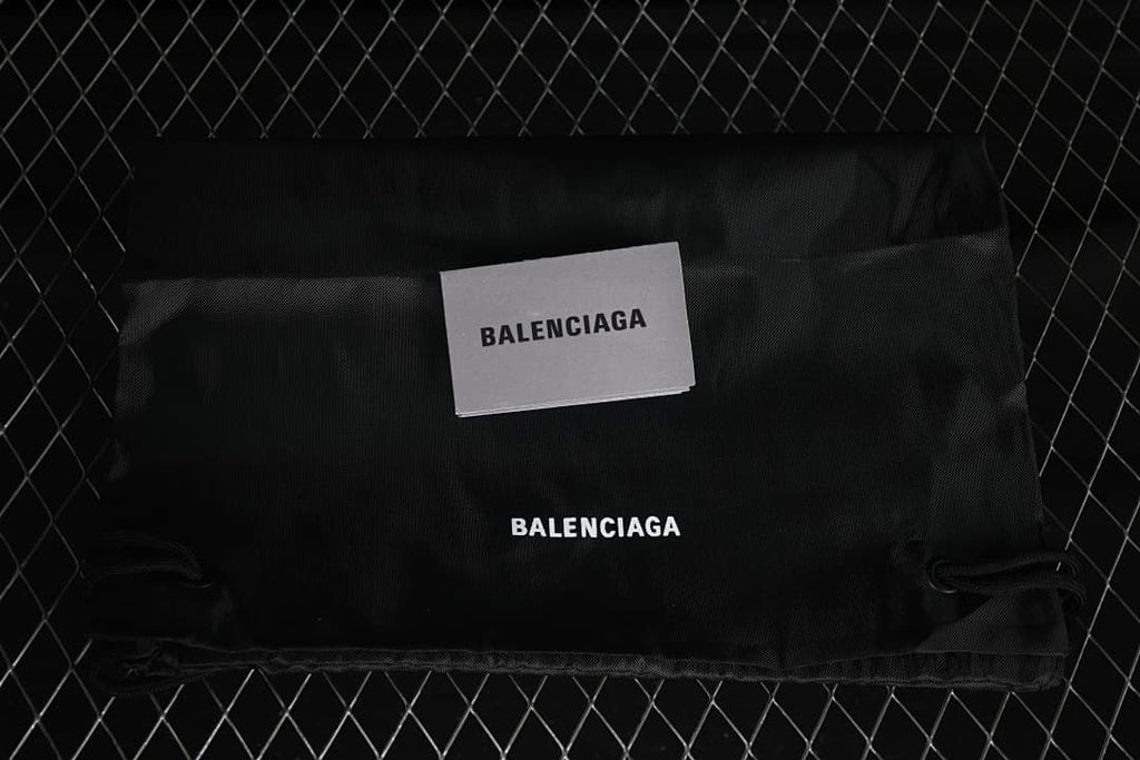 Black branded drawstring bag and card shown with the sneakers.
